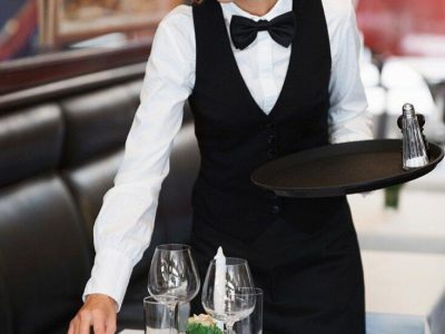 Kellnerin deckt den Tisch im Restaurant