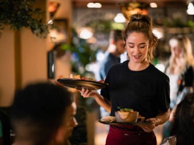 A waitress serving customers food at a restaurant in Newcastle-Upon-Tyne.